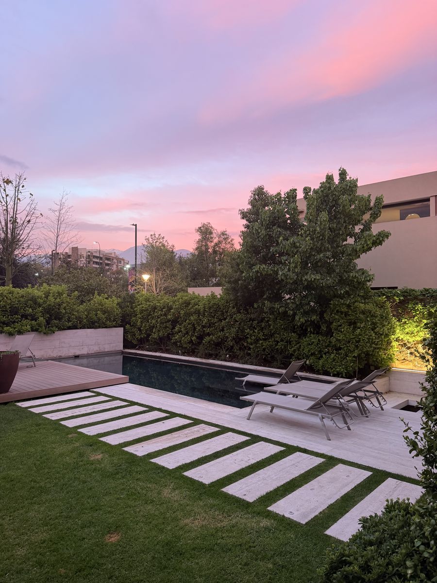 Jardín y terraza al atardecer rosado, con la prueba de iluminación encendida
