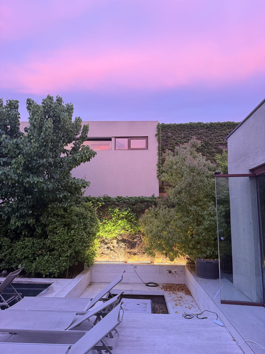 Jardín y terraza al atardecer rosado, con la prueba de iluminación encendida